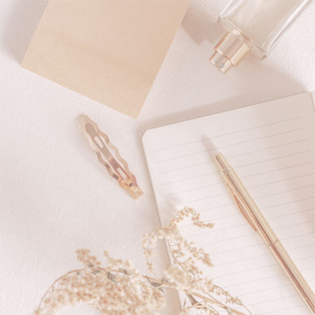 lined notebook, pen, perfume bottle, hair clip, and dried flower Dr. Christine Rodgers Denver Plastic Surgery