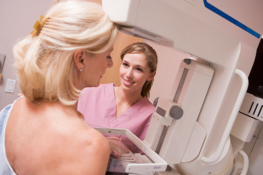Woman at appointment receiving a mammogram.