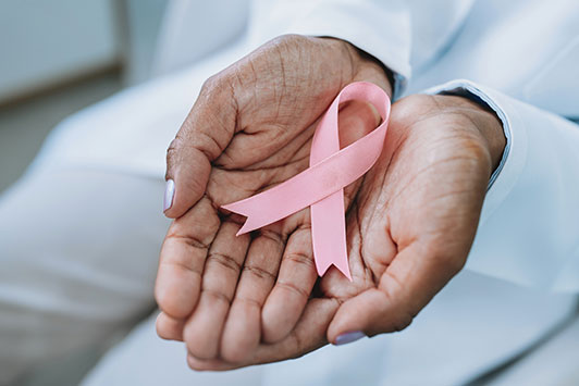 HIands holding a breast cancer ribbon