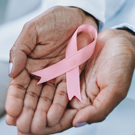 woman's hands holding a breast cancer ribbon - thumbnail